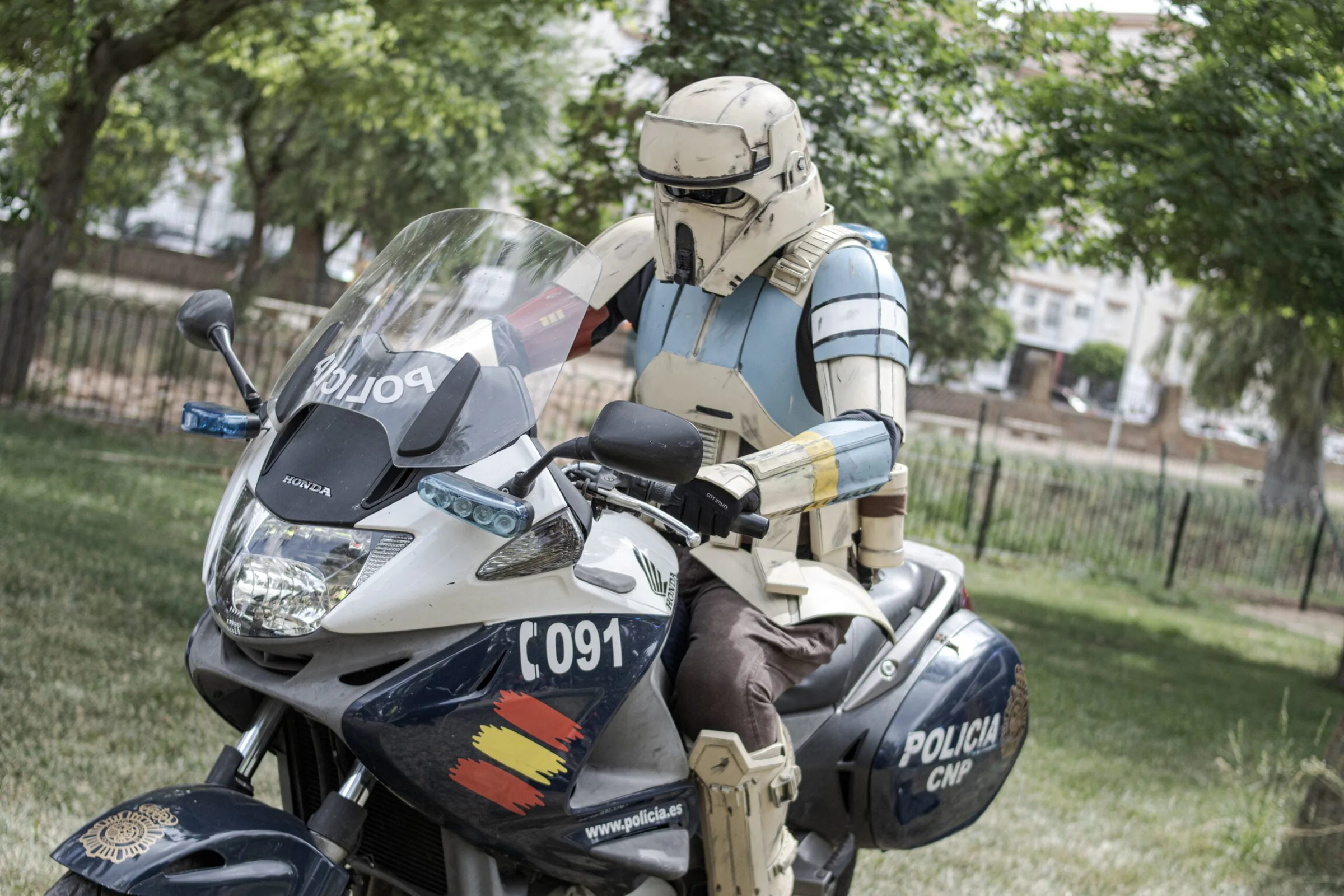 Personaje con armadura de ciencia ficción posando sobre una motocicleta