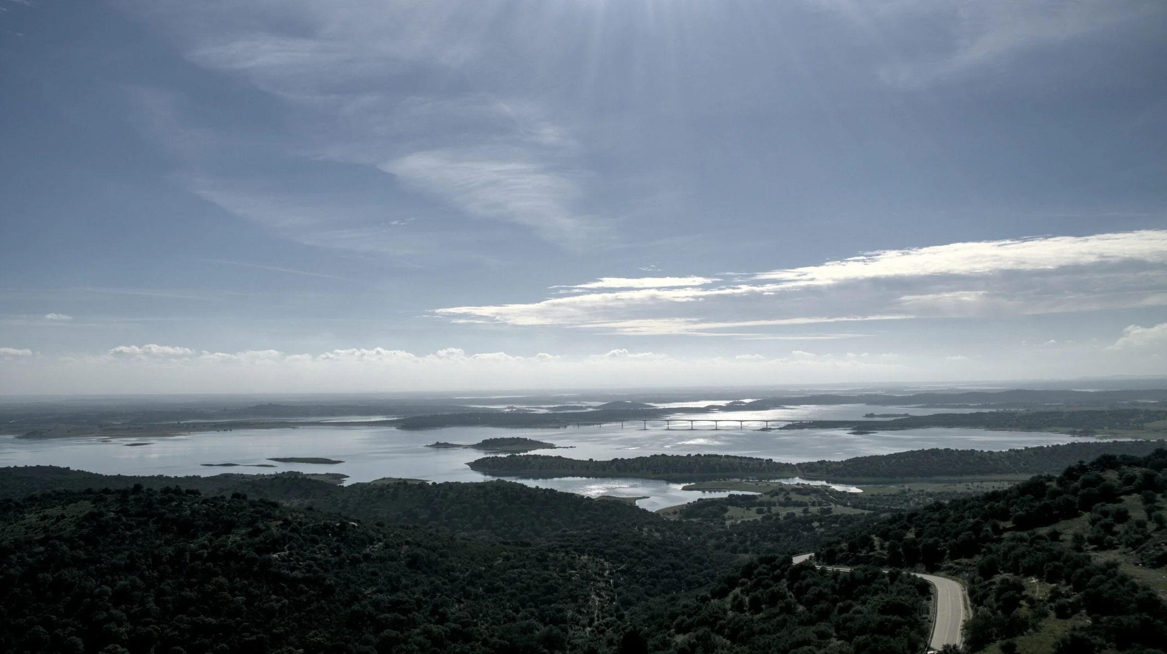 Panorámica de embalse y montañas bajo un cielo dramático