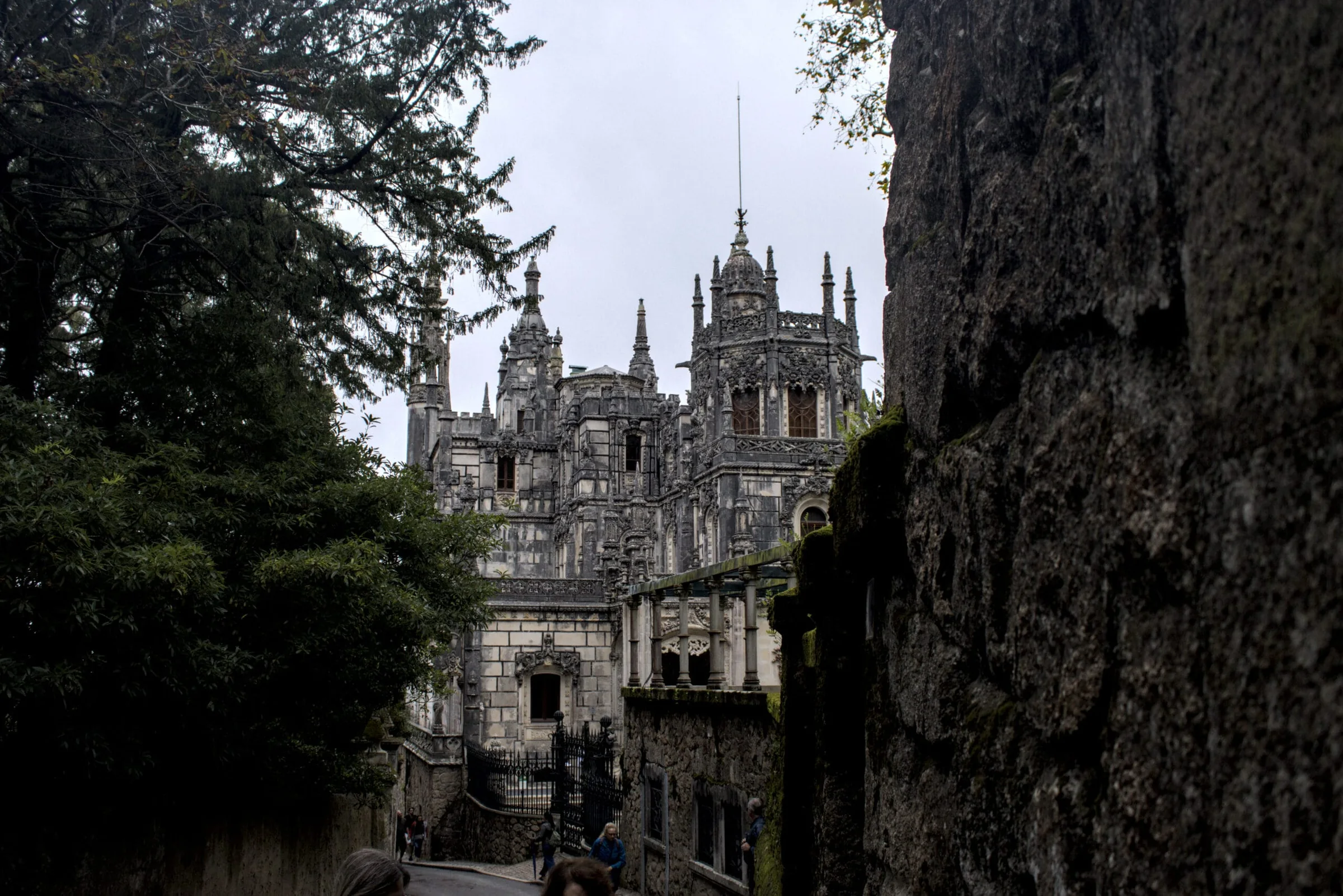 Catedral enmarcada por árboles y muros de piedra