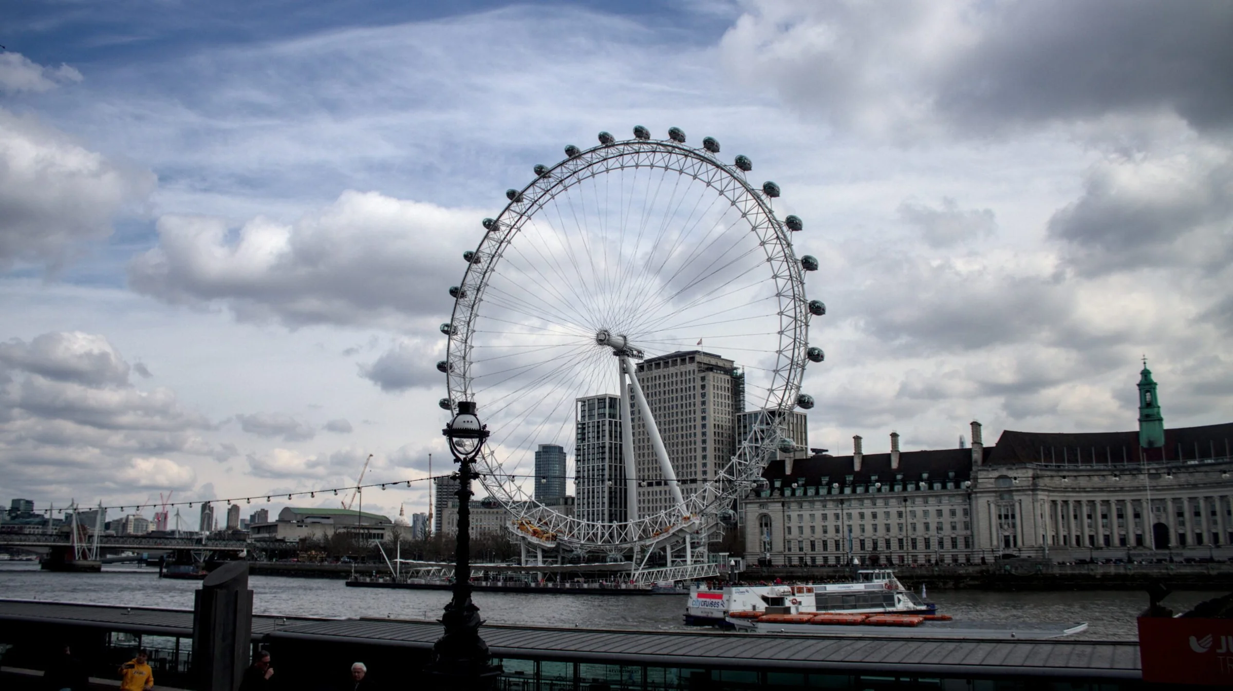 Vista urbana de Londres con el London Eye bajo un cielo nublado