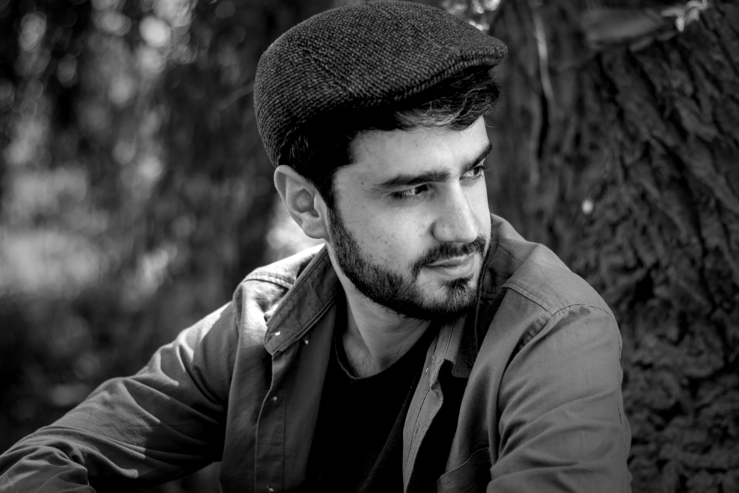Retrato masculino en blanco y negro realizado junto a un árbol