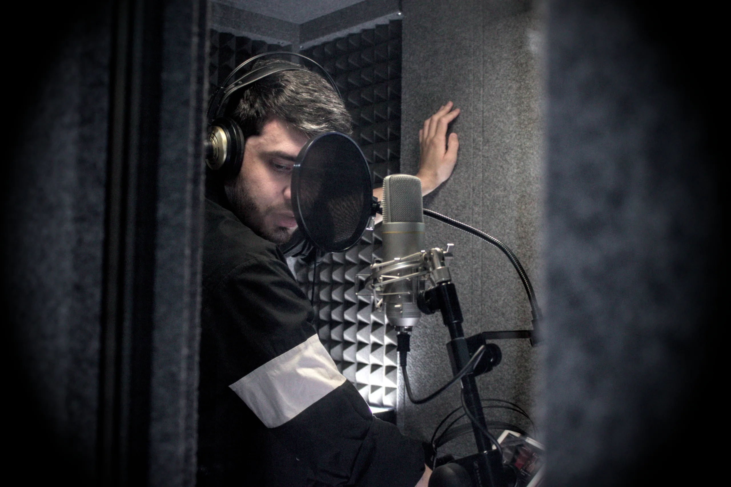 Intérprete grabando ante un micrófono en un estudio de sonido